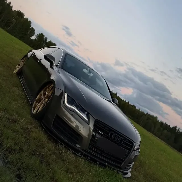 Tumma Audi A7 kultaisilla vanteilla