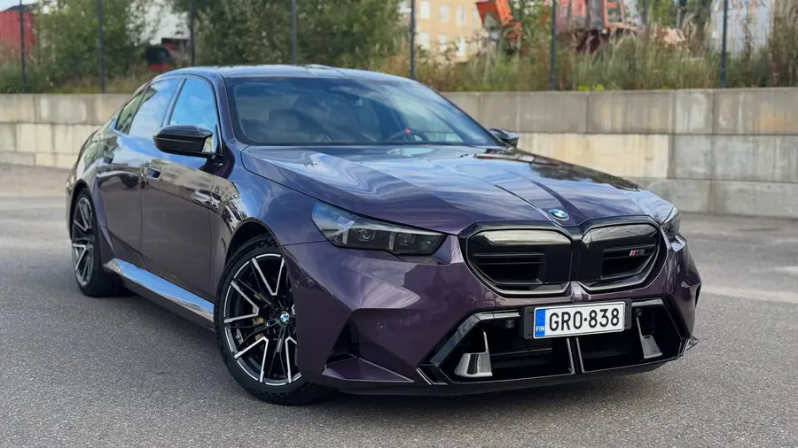Violetti BMW M5 edestä hallin pihalla