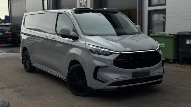 Harmaa Ford Transit Custom hallin pihalla